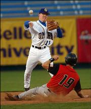 Omaha's Kevin Hooper (11), a Lawrence High product, throws to first
to complete a double play against the Albuquerque Isotopes on
Wednesday in Omaha, Neb.