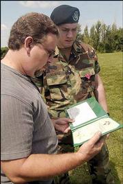 Terry Myers, left, and his son Sgt. Jared Myers look at the
certificate that accompanied Jared Myers' Bronze Star. Myers
received the Bronze Star on Sunday for his valor in Iraq.