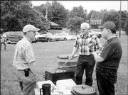 From left, Don Edman, Gary Beasley and Rene Santos, members of the
Lawrence Noon Lions Club, grill hot dogs and hamburgers at a picnic
for Lawrence residents with visual impairments. The picnic was June
19 at Holcom Park.