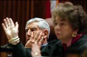 Kansas Supreme Court Justice Donald Allegrucci, left, and Chief
Justice Kay McFarland listen to oral arguments on the state school
finance lawsuit. The court must decide whether the current school
finance system is constitutional.