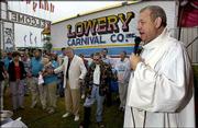 THE REV. JOHN VAKULSKAS LEADS a group of carnival workers in prayer
as he says Mass at the Missouri State Fair in Sedalia, Mo.
Vakulskas has traveled the country to minister to carnival workers
for the past 35 years.
