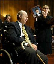 Gun-control advocate James Brady, left, reacts emotionally to a
plea by Bryl Phillips-Taylor, of Richmond, Va., as she displays a
photo of her son Scott, who was killed by a classmate armed with an
AK-47 in 1989. Some congressional Democrats and police leaders from
across the country called on President Bush Wednesday to urge
Congress to approve the renewal of the assault weapons ban, which
is set to expire Monday. Police Chief Joe Polisar, of Garden Grove,
Calif., president of the International Association of Chiefs of
Police, listens with head bowed at left rear.