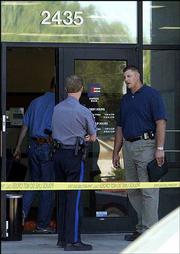 Lawrence police Sgt. Craig Shanks, center, and Detective Lance Flachsbarth, right, talk outside Emprise Bank, 2435 Iowa, shortly after a 2004 bank robbery as another detective enters the
bank. Flachsbarth was one of the trainers at the Citizen's Academy and talked about investigating crimes against children.