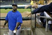 Kansas City's Calvin Pickering hands out signed baseballs during a
rain delay. The Royals' scheduled game Wednesday at Detroit was
postponed because of rain and will be made up as part of a
doubleheader today.