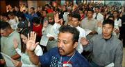 More than 150 people, including Alfredo Martinez, foreground,
Kansas City, Kan., are sworn in as U.S. citizens. Forty-nine
countries were represented at Friday's ceremony.