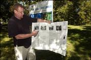 Rich Minder, one of the organizers of the Delaware Street Commons,
unfolds a set of plans at the site. Ground was broken Saturday on
the project, the first of its kind in the state.