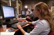 Amanda Tate, St. Louis senior, completes a story for the evening
news broadcast on KUJH-TV. Tate worked in the new Stan and Madeline
Stauffer Multimedia Newsroom that was dedicated Friday at Kansas
University. The newsroom is designed to give KU students real-world
experience by bringing print, broadcast and online news staffs
together.