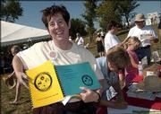 Jean Dirks, Lawrence, and a member of the Unitarian Fellowship,
displays the children's coloring book and a booklet of church
service programs from the past year. She put them in the
Sesquicentennial Time Capsule that was buried Sept. 19 at
Sesquicentennial Point near Clinton Lake dam.