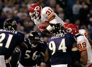 Kansas City running back Priest Holmes (31) dives over Baltimore's
Marques Douglas (94), Edgerton Hartwell (56), and Chris McAlister
on his way to scoring the game-winning touchdown. The Chiefs picked
up their first win this season, a 27-24 victory Monday in
Baltimore.