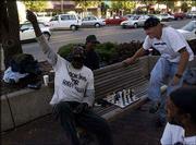 Willie Moore celebrates his win over Mike Gabb, of Lawrence, as
Jeffery Clark, top, and Sherman "Sly" Talbert, bottom right, watch
at the southwest corner of 10th and Massachusetts streets. Willie
and Sly honed their chess skills while serving time together at
Lansing State Prison.