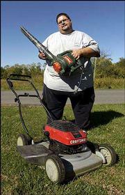 Bill Heeter displays the lawn equipment he received for free at his
home in Grain Valley, Mo. Heeter got the equipment through a Kansas
City freecycling group after giving away more than 1,000 books
through the same group.