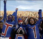 KU students Jesse Plous, left, Lindsey Gold, center, and Josh
Bailey cheer before the start of the Jayhawks' game against Kansas
State. A near-sellout crowd watched the Jayhawks beat the Wildcats,
31-28.