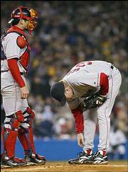 Boston starter Curt Schilling examines his right foot in the fourth
inning with catcher Jason Varitek. Schilling and the Red Sox won,
4-2, Tuesday night in New York.
