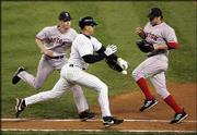 New York's Alex Rodriguez knocks the ball out of the glove of
Boston pitcher Bronson Arroyo, left, as first baseman Doug
Mientkiewicz looks on during the eighth inning. Rodriguez initially
was called safe, but after a conference by the umpires was called
out for interference. The Red Sox won Game 6 of the AL championship
series, 4-2, Tuesday in New York.