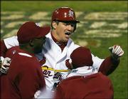 St. Louis' Scott Rolen, center, celebrates after hitting a two-run
homer. The Cards won, 5-2, Thursday night in St. Louis.