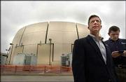 James Crites, left, executive vice president of Dallas/Fort Worth
Airport operations, stands with Ken Capps in front of a
6-million-gallon thermal storage tank during a tour at the airport
in Grapevine, Texas. The tank lets the airport chill
air-conditioner coolant in the middle of the night and save money
on its cooling costs.