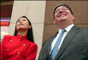 Godzilla conference organizers Michiko Ito, left, and William
Tsutsui gaze toward the roof of Liberty Hall as a 28-foot Godzilla
balloon is inflated.