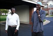 Peter Nyarol Dut, right, jokes with friend Simon Deng outside Dut&squot;s
home in Overland Park. Dut stars in the documentary "Lost Boys of
Sudan," released on DVD this week.