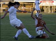 Kansas University sophomore defender Holly Gault, left, boots the
ball past Texas defender Paige Carmichael in the first half. The
Jayhawks lost, 3-2 in double overtime, in the semifinals of the Big
12 Conference soccer tournament Friday in San Antonio.