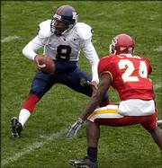 Kansas University's Jason Swanson, left, pitches under pressure
from Iowa State's LaMarcus Hicks in the third quarter of Saturday's
game. Swanson will start today against Colorado -- and hope to
avoid the bad luck that seems to have hounded KU's quarterbacks
lately.
