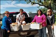 University National Bank employees, from left, Lori Kloepper and
Annette Thede deliver nonperishable foods to Pelathe Community
Resource Center during the Fall Day of Caring. Caroline Hicks, of
Pelathe center, and Linda Elwell, right, chairwoman of the Fall Day
of Caring, helped unload the food Sept. 24 at the center.