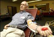 Chuck McPheeters squeezes his hand to get the blood flowing in his
arm while giving blood at the American Red Cross blood drive at
First Christian Church, 1000 Ky. McPheeters, also a Red Cross
volunteer, has given more than 100 pints of blood, including the
one he donated Wednesday.