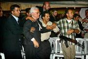 Mahmoud Abbas, former Palestinian prime minister and the successor
of Yasser Arafat as PLO chief, is hustled away by bodyguards after
gunfire erupted at a tent set up for mourners of Arafat in Gaza
City. Two security guards were killed Sunday and five people were
wounded, hospital officials said.