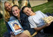 Lori Mackey, left, founder of "Prosperity 4 Kids," poses with her
children Briana, 11, center, and Devin, 9, outside their home in
Agoura Hills, Calif. Mackey, who was discouraged by the lack of
resources available to teach her children about money, came up with
a piggy bank system and a book "Money Mama & the Three Little
Pigs."