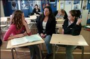Lawrence Alternative High School senior Rachel Moore, 17, left,
talks with social studies instructor Kim Grinnell, who's been at
the school for nine years, and senior Kicki Metz, 17.