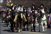 Dressed in outfits from the late 1800s, members of the Wild Women
of the Frontier wave and shout to parade-goers lining the
intersection of Ninth and Massachusetts streets. The brigade was
part of the annual Old-Fashioned Christmas Parade on Saturday.