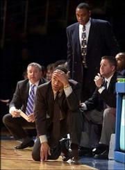 TCU coach Neil Dougherty, kneeling, shows his dismay during the
Horned Frogs' 93-74 loss to Kansas University. Dougherty, a former
KU assistant coach, made his first visit to Allen Fieldhouse as an
opposing coach Thursday.