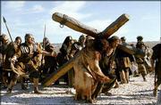 JARRETH MERZ, who plays Simon of Cyrene, right, helps Jim Caviezel,
portraying Jesus Christ, carry a cross on the set of 'The Passion
of the Christ.'
