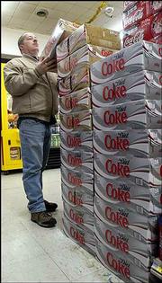 Marty Sutton, of Jonesville, Ind., selects a case of caffeine free Diet Coke at a store in Walesboro, Ind. Soda makers are offering more diet brands as consumers increasingly pick diet soda over regular soda.