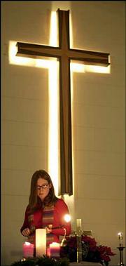 Hannah Newson, Lee's Summit, Mo., lights candles. The church, 609
E. 550 Road, was abuzz with activity as families gathered to
celebrate.<br>