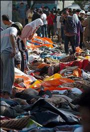 The bodies of tsunami victims are piled in the central square of
Banda Aceh, capital city of Indonesia's Aceh province. The death
toll in a tidal wave triggered by an earthquake that slammed into
coasts of several south and southeast Asian countries topped 22,500
Monday.