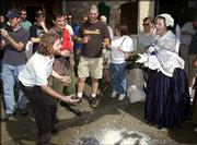 Phil Ostronic, of Lawrence, pleads with Eugenia Harte, of Missouri,
not to dump the alcohol found at Free State Brewing Co. during a
temperance rally. Re-enactors paraded down Massachusetts Street and
begged citizens to give up their grog as part of the Chautauqua
events in June.