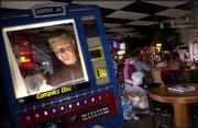 Patrick Conroy, owner of Crown Amusements and Games, Lawrence,
cleans a jukebox at the Crosstown Tavern during a November stop to
collect money from his coin-operated machines. Conroy said the
business had lost money since the city's smoking ban took effect
July 1.