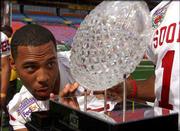 Oklahoma defensive back Eric Bassey studies the
national-championship trophy during a break in Sunday's media day.
The winner of tonight's Orange Bowl in Miami takes the hardware
home.