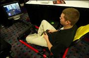 Justin Campbell demonstrates the Hot Seat at the Consumer
Electronics Show. The gaming chassis features surround sound and
vibration for an arcade-like experience in the home.