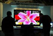 Workers at Samsung's booth at the Consumer Electronics Show adjust
the world's largest plasma television, a 102-inch screen prototype,
at the Las Vegas Convention Center. The annual trade show occupies
1.5 million square feet of exhibit space and attracts 120,000
attendees.