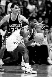 KU's Terry Brown looks to pass around a Kentucky defender in this file photo from a game against Kentucky on Dec. 9, 1989.