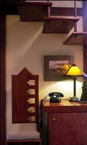 Owner Paul Penfield milled trees from the property to build
cabinets and furniture -- such as platform beds, chairs and tables
-- based on Frank Lloyd Wright's angular designs. Finishing touches
include items like a rotary phone and a typewriter that keep the
feel of the decade in which the home was built.