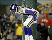 Minnesota receiver Randy Moss bends over to mock moon Packers fans
at Lambeau Field. The Vikings won, 31-17, Sunday in Green Bay,
Wis., but Moss may face a fine for the celebration.