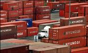 A truck passes through a field of containers at the Port of Long
Beach. America's trade deficit soared in November as Americans'
appetites for foreign oil and imported food rose.