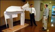 Brad Kemp, left, assistant director of KU's Natural History Museum,
and Bruce Scherting, exhibits director, look over a model of
Comanche. The model was built to make sure the real Comanche can be
safely navigated through the building to his new exhibit space.