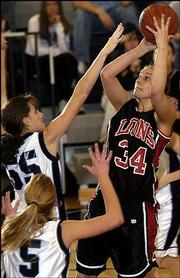 Lawrence High's Megan Klingler (34) triggers over Olathe
Northwest's Janelle Wehr (55) and Samantha Ronnebaum. The Lions
beat the Ravens, 53-23, Friday in Olathe.