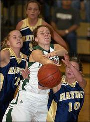 Free State High's Chloe Hall, center, fights for a loose ball
against Topeka Hayden's Jenny Hubbell, left, and Morgan Gaffney.
The Firebirds won their first-round game of the Firebird Winter
Classic, 52-32, Thursday night at FSHS.