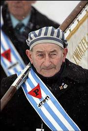Many survivors displayed their inmate numbers. Some wore the red
triangle patches that the Nazis issued to Polish political
prisoners to distinguish them from Jews.