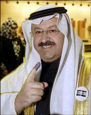 Iraqi Interim President Ghazi al-Yawer holds up his ink-stained
finger after casting his vote in the Iraqi elections today in
Baghdad, Iraq.