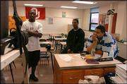 Kansas CIty (Kan.) Washington football players Grady Henderson,
left, and Darrell Stuckey, center, watch highlights of the 2004
season with their coach, Darwin Franklin. Stuckey will fulfill a
dream and keep a promise by signing a letter of intent with Kansas
University.